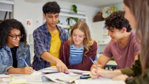 A group of diverse young adults working together on a collaborative group project at a desk, showcasing educational Team Building Activities.