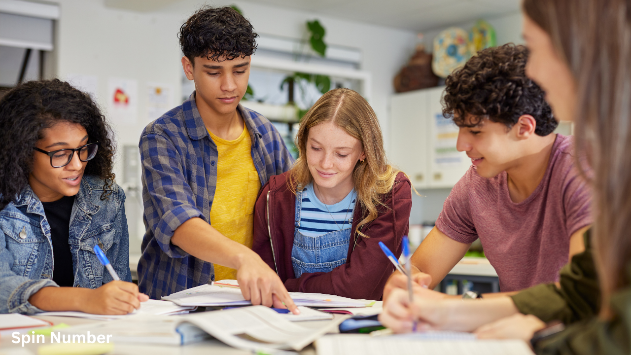 A group of diverse young adults working together on a collaborative group project at a desk, showcasing educational Team Building Activities.
