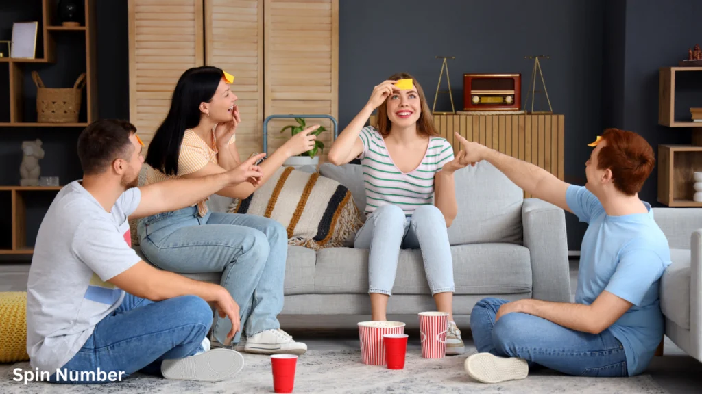 A group of four friends laughing and pointing as they play a sticky-note guessing game in a cozy living room, illustrating interactive Party Games for Adults.