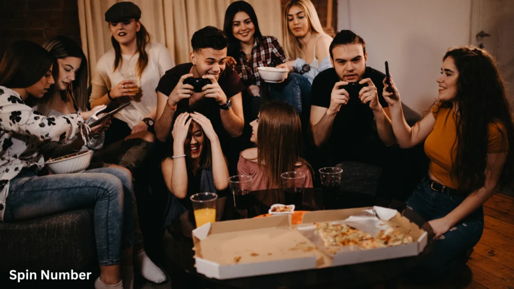 A group of friends laughing and cheering while playing video games and eating pizza in a living room, capturing the lively spirit of Minute to Win It Games.