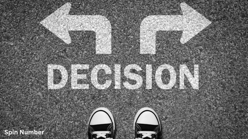 Top-down view of a person's sneakers on asphalt with the word "DECISION" and directional arrows painted on the ground, representing a crossroads before spinning a Decision Wheel.