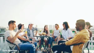 A diverse group of friends laughing and drinking together on a rooftop patio, perfectly capturing the fun vibe of playing Never Have I Ever Questions.
