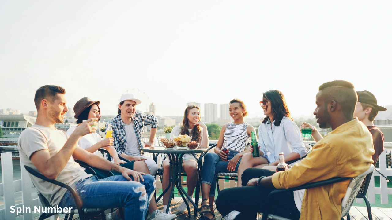 A diverse group of friends laughing and drinking together on a rooftop patio, perfectly capturing the fun vibe of playing Never Have I Ever Questions.