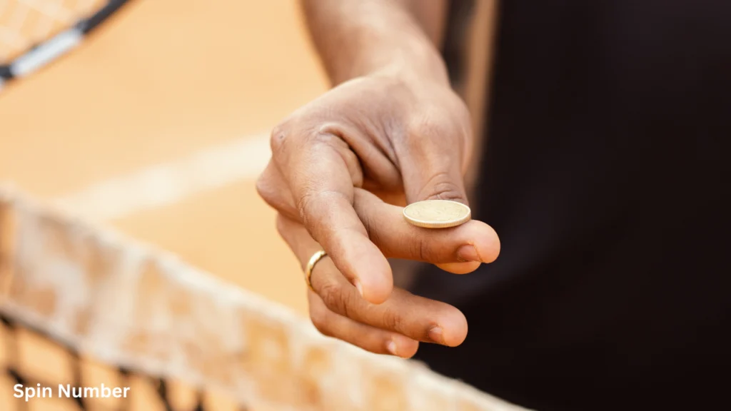 A tennis referee or player holding a gold coin on their fingertips near the net, preparing to Flip a Coin to decide who serves first.