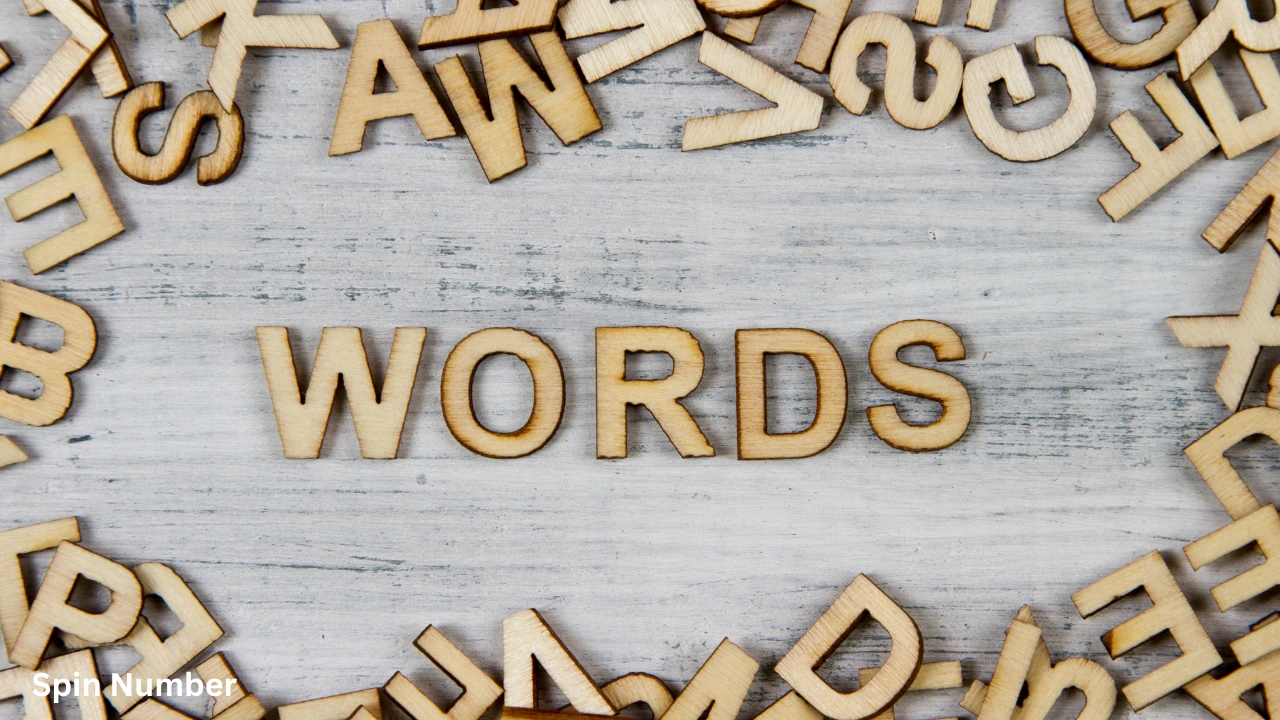 Wooden alphabet letters scattered on a rustic white table surrounding the central word "WORDS", ideal for selecting challenging Hangman Words.