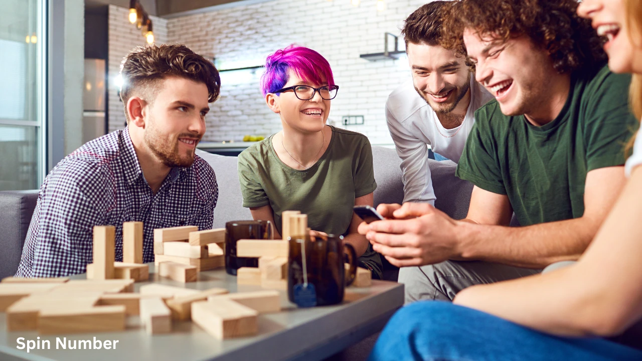 A group of smiling friends gathered around a coffee table looking at a smartphone to choose fun This or That Questions.